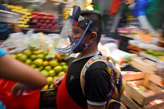 Un jeune garçon porte un masque en plexiglas au marché de San Cosme à Mexico le 10 août 2020<br />
 [Alfredo ESTRELLA / AFP]