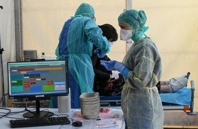 Examen d'une patiente dans une celluel médicale dédiée au Covid-19, à l'hôpital Saint-Roch à Montpellier, le 8 avril 2020 [Pascal GUYOT / AFP]