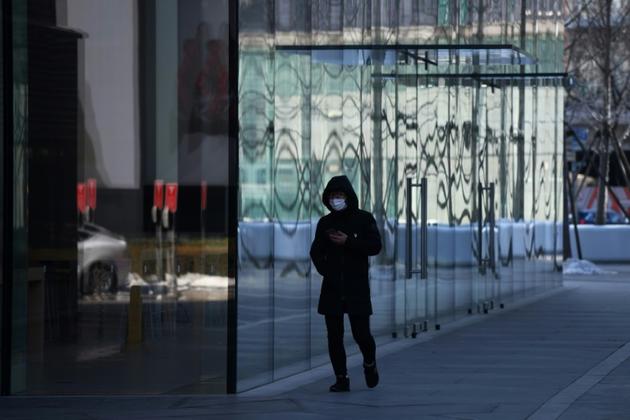 Un passant devant un Apple Store de Pékin fermé au public, le 8 février 2020 [GREG BAKER / AFP/Archives]