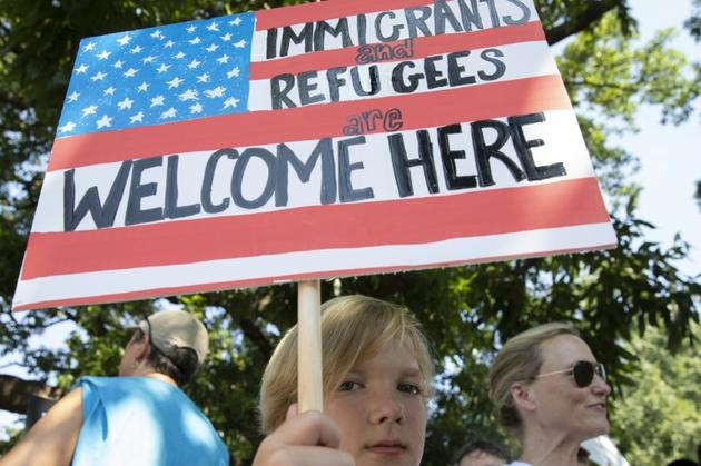 "Les immigrés et les réfugiés sont les bienvenus": un jeune manifestant, le 30 juin 2018 à Washington [Alex Edelman / AFP]