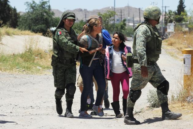 Des membres de la Garde nationale mexicaine arrêtent des femmes et une fillette s'apprêtant à franchir le Rio Bravo entre Ciudad Juarez au Mexique et El Paso aux Etats-Unis, le 21 juin 2019 [HERIKA MARTINEZ / AFP/Archives]