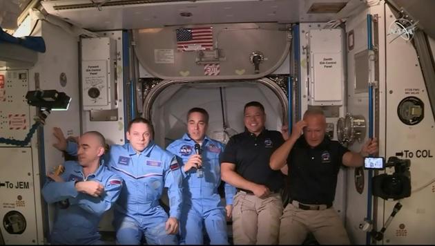 Image transmise par la Nasa de Robert Behnken (2e d) et Doug Hurley (d), à leur arrivée dans l'ISS, avec les autres astronautes de la station spatiale, le 31 mai 2020 [Handout / NASA TV/AFP/Archives]
