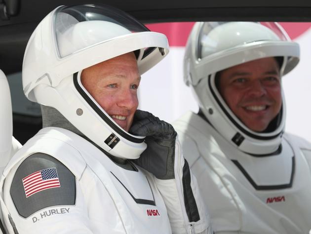 Les astronautes américains Bob Behnken (d) et Doug Hurley avant leur décollage à bord de la capsule Crew Dragon de SpaceX, le 30 mai 2020 à Cap Canaveral, en Floride [JOE RAEDLE / GETTY IMAGES NORTH AMERICA/AFP/Archives]