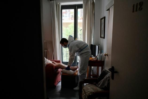 Un soignant examine un résident d'une maison de retraite le 24 avril 2020 à Madrid [OSCAR DEL POZO / AFP]