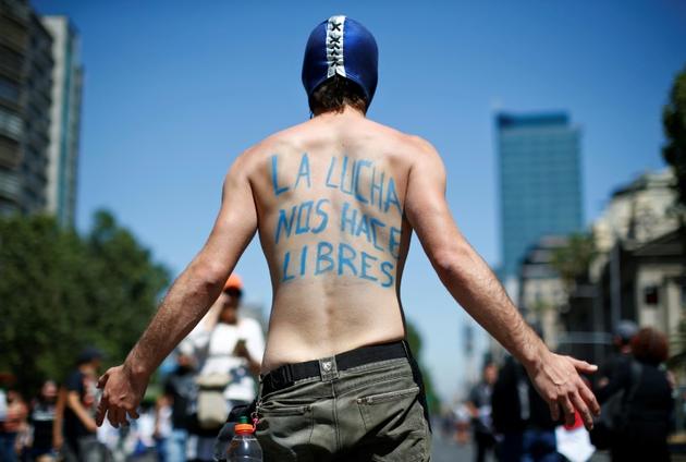 Un manifestant à Santiago, le 23 octobre 2019. [Pablo VERA / AFP]