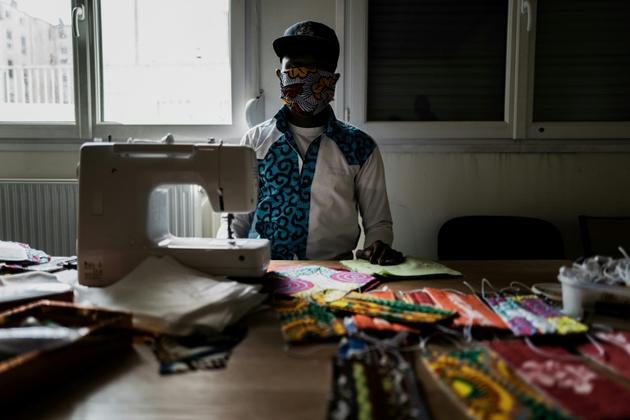 Un homme coud des masques dans une école temporairement reconvertie en centre d'accueil pour migrants, le 16 avril 2020 à Lyon  [JEFF PACHOUD / AFP/Archives]