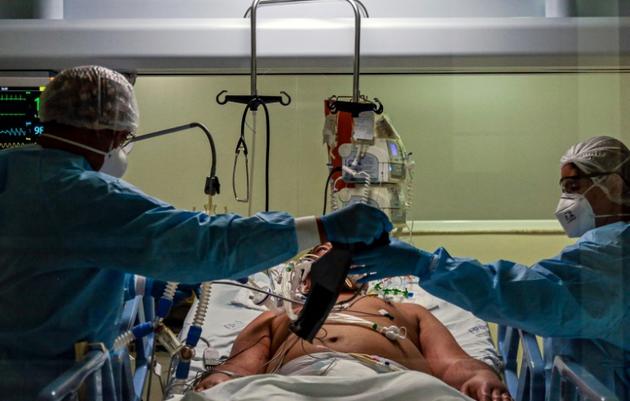 Des personnels soignants s'occupent d'un patient atteint du coronavirus dans une unité de soins intensifs à l'hôpital Emilio Ribas de Sao Paulo, le 20 avril 2020 au Brésil [Miguel SCHINCARIOL / AFP/Archives]
