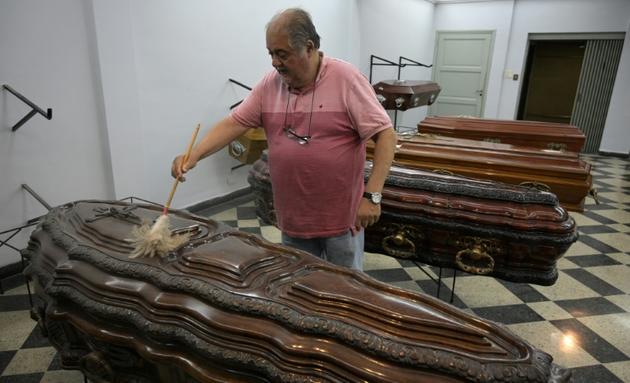 Eduardo Tapia, propriétaire d'une maison funéraire à Buenos Aires, nettoie un cercueil le 3 décembre 2019 [JUAN MABROMATA / AFP/Archives]