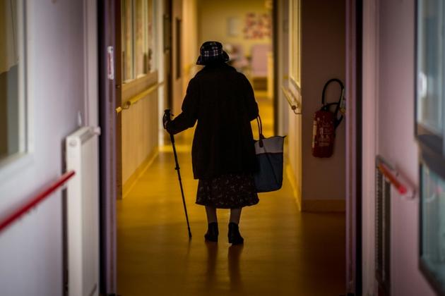 Une résidente d'un Ehpad de Brest marche dans un couloir de l'établissement, le 4 mars 2020 [Loic VENANCE / AFP]