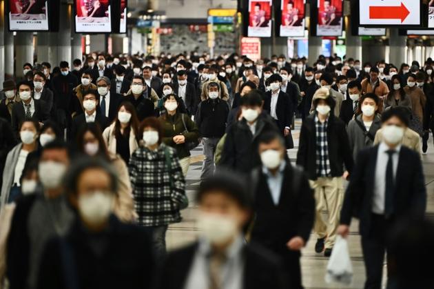 Des personnes portant un masque de protection se rendent sur leurx lieux de travail, le 16 avril 2020 à Tokyo [CHARLY TRIBALLEAU / AFP]