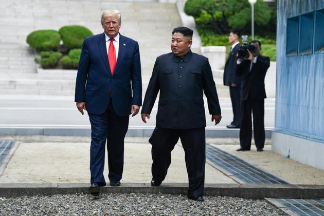 Donald Trump et Kim Jong Un traversent la ligne de démarcation intercoréenne, le 30 juin 2019 à Panmunjom [Brendan Smialowski / AFP/Archives]