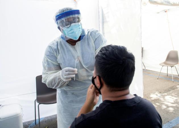 Un personnel médical prend un échantillon nasal d'un patient sur le site de John's Well Child à Los angles le 24 juillet [VALERIE MACON / AFP]