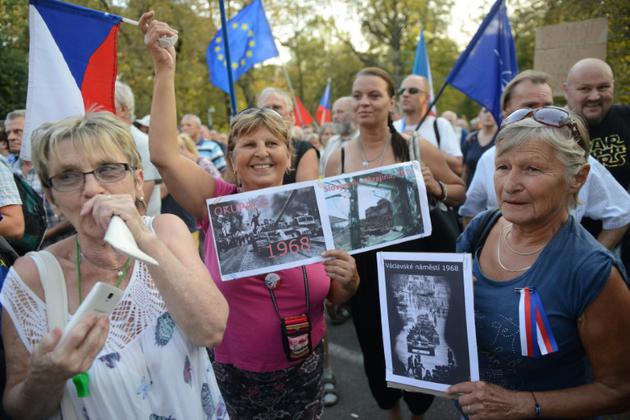 Des femmes brandissent des photos de l'invasion soviétique de 1968 le 21 août à Prague, en République tchèque<br />
 [Michal CIZEK / AFP]
