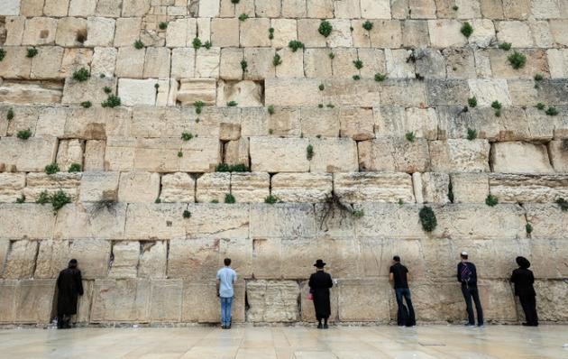 Des fidèles prient devant le Mur des Lamentations à Jérusalem, le 12 mars 2020 [Emmanuel DUNAND / AFP]