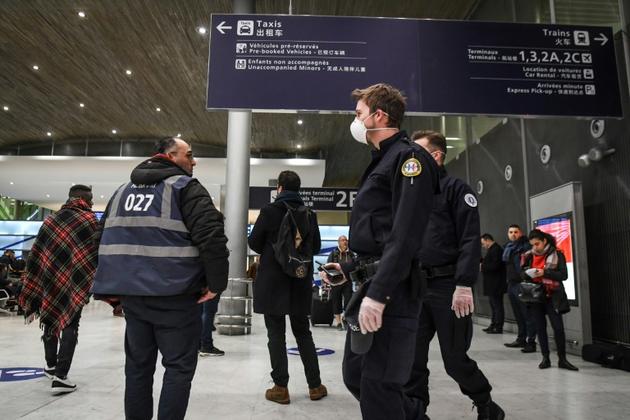 Des policiers portant des masques patrouillent le 26 janvier 2020 à l'aéroport de Roissy  [Alain JOCARD / AFP]