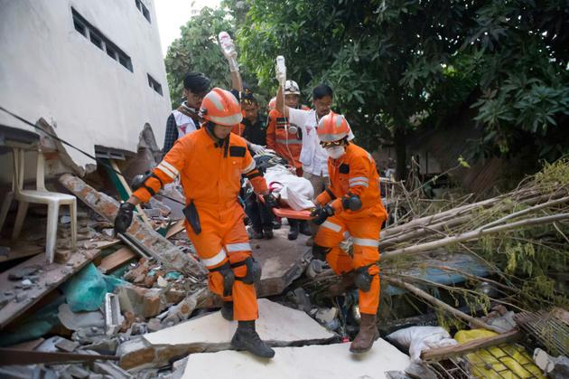 Des secouristes évacuent un survivant des décombres d'un restaurant, le 30 septembre 2018, après un séisme et un tsunami à Palu, sur l'île des Célèbes en Indonésie [BAY ISMOYO / AFP]