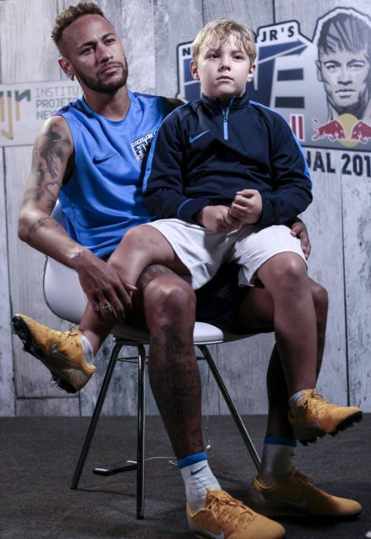 Neymar, son fils Davi Lucca sur les genoux, accorde un entretien à l'AFP à Praia Grande, près de Sao Paulo  [Miguel SCHINCARIOL / AFP]