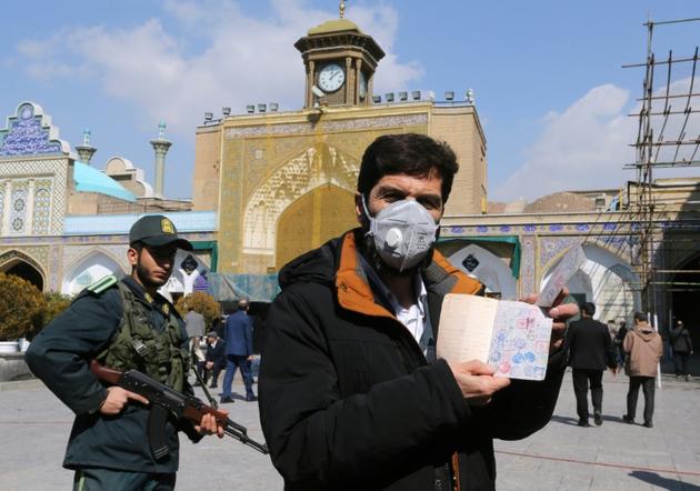 Un Iranien porte un masque de protection pour aller voter aux élections législatives, dans la banlieue de Téhéran, le 21 février 2020  [ATTA KENARE / AFP]