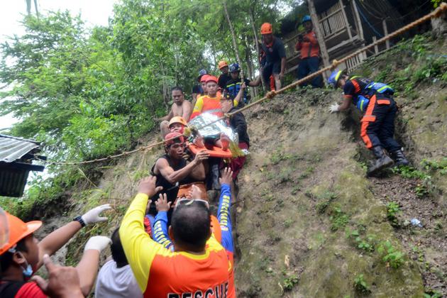 Des sauveteurs évacuent un blessé après un glissement de terrain, le 20 septembre 2018 dans le village de Tina-an, sur l'île philippine de Cebu [ALAN TANGCAWAN / AFP]