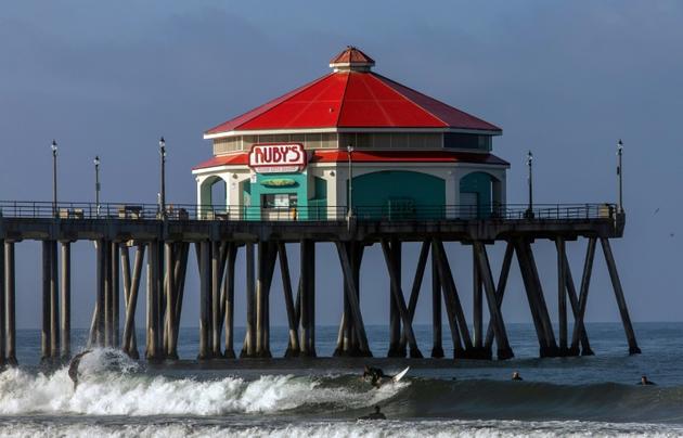 Des surfeurs près de la jetée d'Huntington Beach, le 2 mai 2020 en Californie [Apu GOMES / AFP]