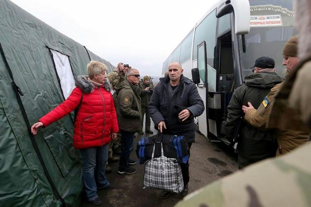 Des prisonniers ukrainiens descendent d'un bus après avoir été libéré contre des prisonniers pro-russes au checkpoint Mayorsk [HO / UKRAINIAN PRESIDENTIAL PRESS SERVICE/AFP]