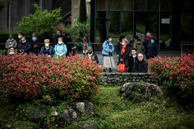 Des pèlerins devant avant la réouverture du sanctuaire de Lourdes, fermé pour la première fois de son histoire pendant deux mois, pour cause d'épidémie, le 16 mai 2020 à Lourdes [Lionel BONAVENTURE / AFP]