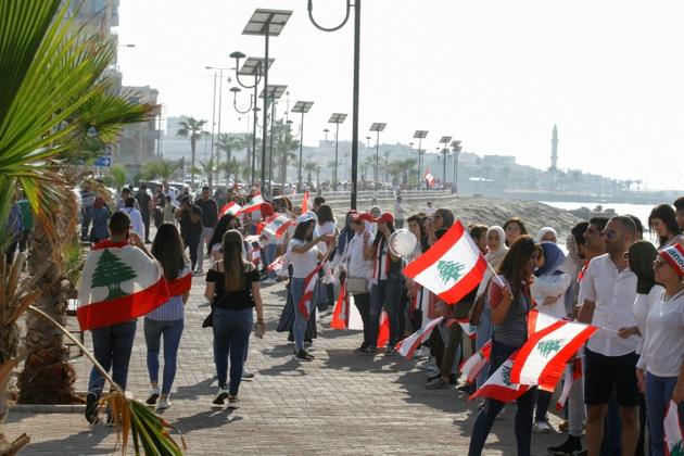 Les manifestants libanais forment une chaîne humaine, à Saïda, le 27 octobre 2019 [Mahmoud ZAYYAT / AFP]