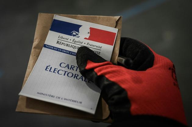 Une personne vote, gantée, le 15 mars 2020 à Paris [Philippe LOPEZ / AFP/Archives]