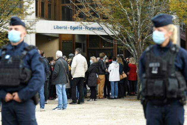Recueillement devant l'école de Conflans-Sainte-Honorine, le 17 octobre 2020 au lendemain de l'assassinat par décapitation d'un de ses enseignants  [Bertrand GUAY / AFP]
