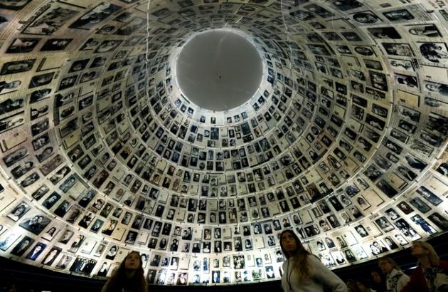 Des visiteurs regardent le mur recensant les noms et visages de victimes de la Shoah, au mémorial de Yad Vashem, le 20 janvier 2020 à Jérusalem [Emmanuel DUNAND / AFP/Archives]