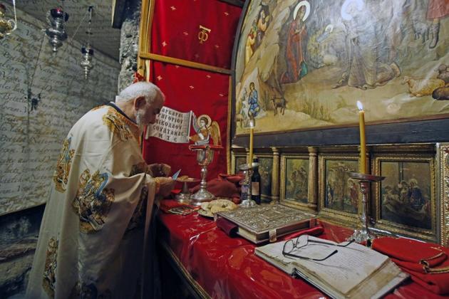 Un prêtre orthodoxe prépare la messe, dans l'église de la Nativité à Béthléhem, le 26 mai 2020 [Musa Al SHAER / AFP]