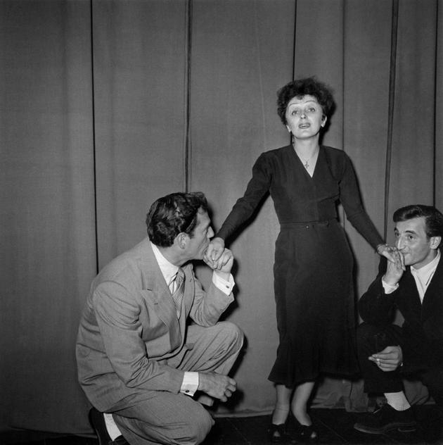 La chanteuse Edith Piaf entourée à gauche par l'acteur Eddie Constantine et à droite par Charles Aznavour à Paris le 1er janvier 1950 [- / AFP/Archives]