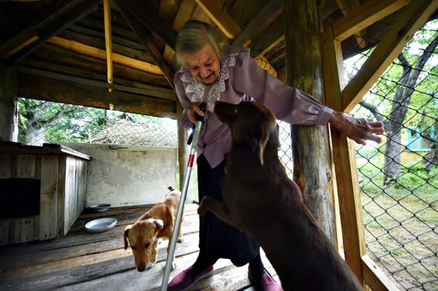 Ianina Statchko, 88 ans, le 11 août 2018 avec ses chiens dans sa maison à Kodi, au Belarus [Sergei GAPON / AFP]