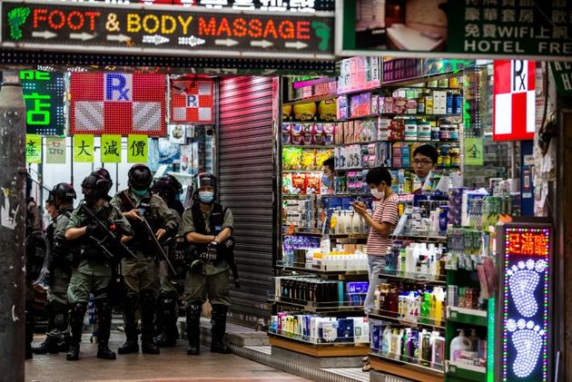 Des policiers postés pour empêcher des manifestants de bloquer els rues de Mongkok, un quartier très animé de Hong Kong, le 27 mai 2020 [ISAAC LAWRENCE / AFP/Archives]