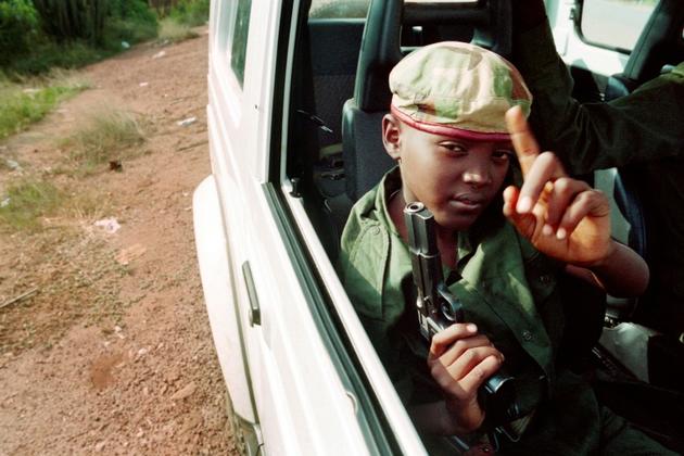 Un enfant armé dans une voiture de la rébellion tutsi du Front patriotique rwandais (FPR), patrouillant dans les rues de Kigali, le 9 juin 1994 [ABDELHAK SENNA / AFP/Archives]