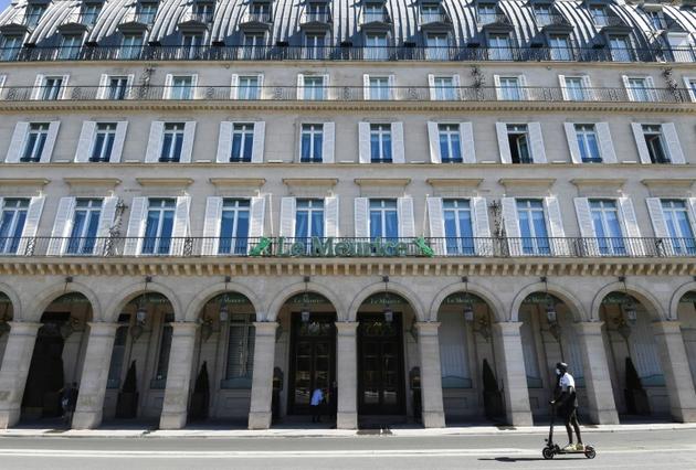 Un homme en trottinette passe devant le grand hôtel Meurice fermé à cause de la crise du coronavirus, le 7 août 2020 à Paris [ALAIN JOCARD / AFP]