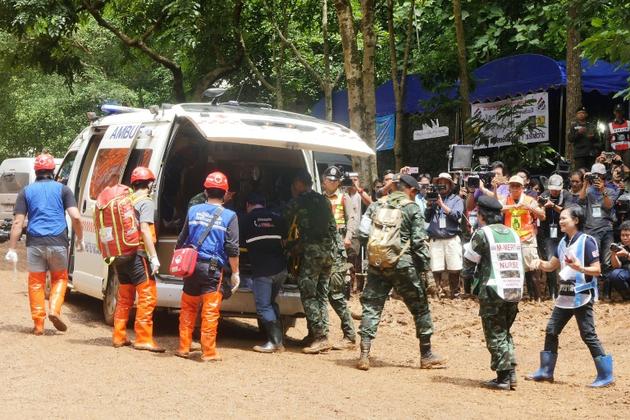 Des équipes de secours lors d'un exercice d'évacuation sur une route boueuse menant à la grotte de Tham Luang où sont piégés douze enfants et leur entraîneur de foot, le 30 juin 2018 à Chiang Rai, en Thaïlande [Sippachai KUNNUWONG / AFP]