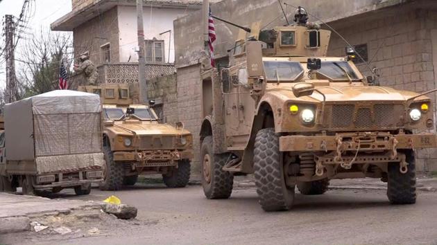 Capture d'écran d'une vidéo obtenue par l'AFPTV le 16 janvier 2019 montre des véhicules blindés américains sur le lieu de l'attentat suicide contre une patrouille américaine de la coalition internationale antijihadistes dans la ville de Minbej dans le nord de la Syrie</p>
<p> [- / AFP]
