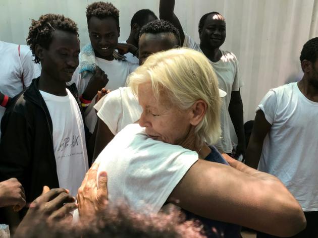 Une infirmière de MSF enlace un migrant à bord du navire Ocean Viking le 23 août 2019, pour célébrer l'annonce d'un prochain débarquement à Malte. [Anne CHAON / AFP]