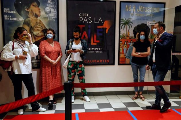Des spectateurs attendent la séance de minuit au cinéma Les 5 Caumartins à Paris, le 21 juin 2020 [Abdulmonam Eassa / AFP]