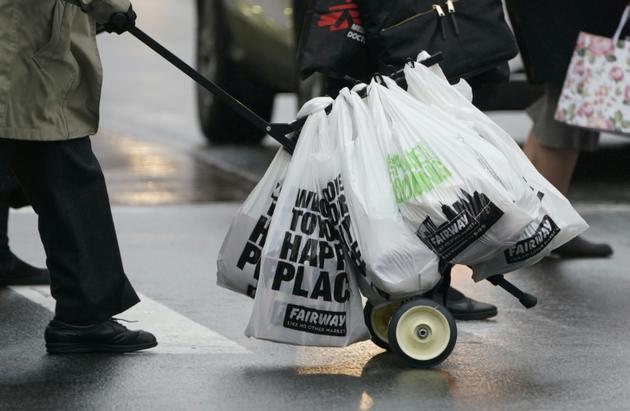 Un homme pousse un chariot de sacs en plastique, chargés de courses, à Manhattan le 28 février 2020, deux jours avant l'entrée en vigueur d'une interdiction de la plupart des sacs en plastique<br />
 [TIMOTHY A. CLARY / AFP]