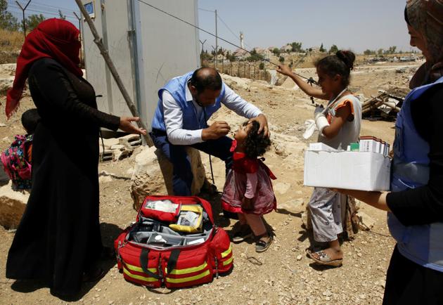 Des Palestiniens se soumettent à un examen médical de l'agence de l'ONU pour les réfugiés (Unrwa), aux environs de Hébron, en Cisjordanie occupée, le 9 août 2018 [HAZEM BADER / AFP/Archives]