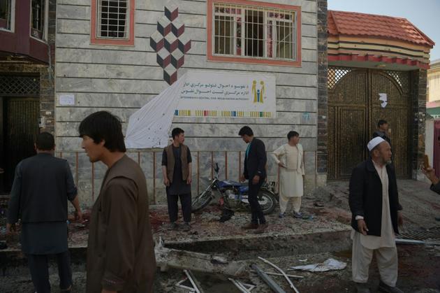 Des habitants inspectent le site d'un attentat-suicide qui a fait quatre morts devant un centre d'inscription sur les registres électoraux, à Kaboul le 22 avril 2018 [SHAH MARAI / AFP/Archives]