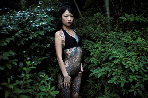 La mannequin japonaise Yuki pose pour une photo, arborant ses tatouages, dans un parc de Tokyo, le 12 juin 2018 [Behrouz MEHRI / AFP]