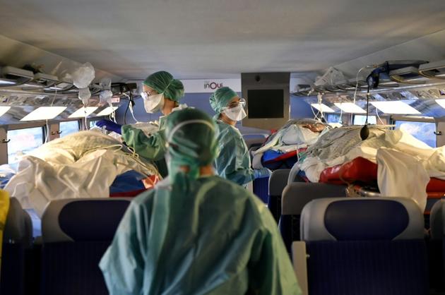 Des infirmières s'occupent dans un TGV médicalisé de patients contaminés évacués vers des hôpitaux de la Nouvelle-Aquitaine, le 29 mars 2020 [Alexandre MARCHI / POOL/AFP]