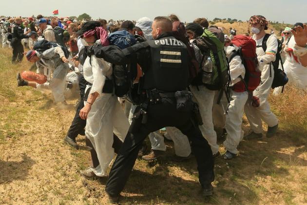 Des policiers tentent d'empêcher des militants écologistes de pénétrer sur le site de la mine de charbon de Garzweiler, dans l'ouest de l'Allemagne, le 22 juin 2019 [David Young / DPA/AFP]