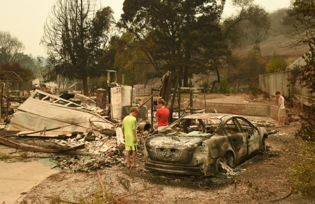 Des enfants sur les lieux de leur maison ravagée par les flammes, à Redding, en Californie, le 27 juillet 2018  [JOSH EDELSON / AFP]