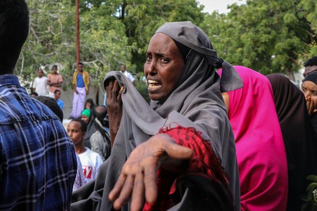 Une femme réagit sur les lieux de l'explosion d'une voiture piégée à Mogadiscio le 28 décembre 2019 [Abdirazak Hussein FARAH / AFP]
