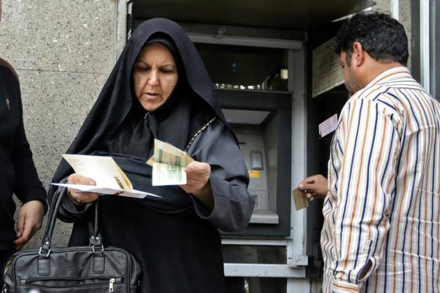 Devant un distributeur automatique à Téhéran le 3 novembre 2018 [ATTA KENARE / AFP]