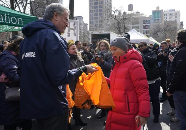 Le maire de New York, Bill de Blasio (à gauche) distribue des sacs réutilisables sur la place de Union Square, à Manhattan, le 28 février 2020  [TIMOTHY A. CLARY / AFP]